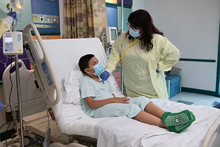A healthcare provider with a patient on a bed