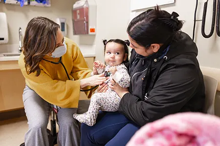 A healthcare provider performing checks on a baby