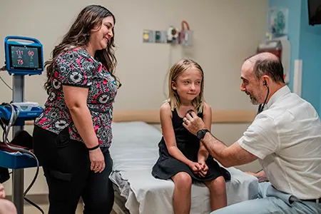 A healthcare provider performs a checkup on a young patient