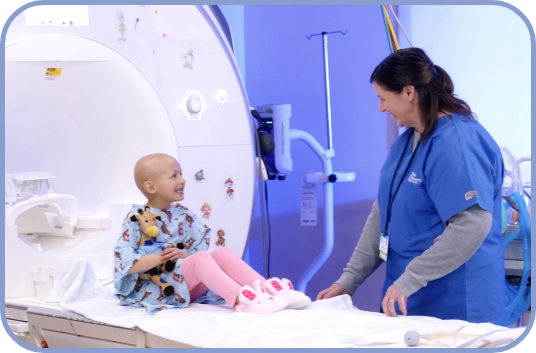 An imaging tech smiles with a young patient
