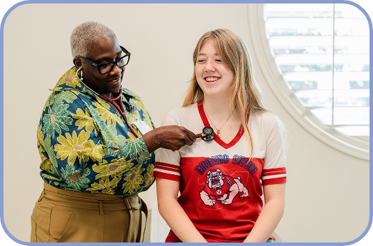 A pediatrician listens to a teenage girl's heartbeat