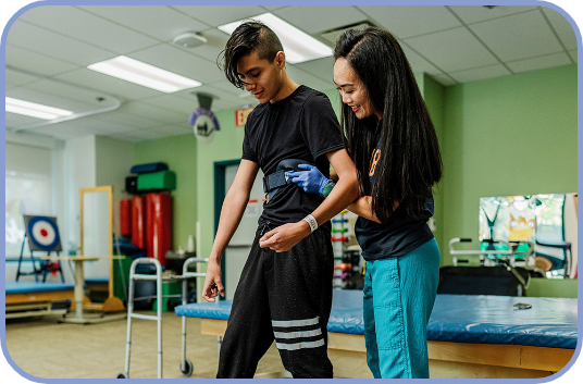 A physical therapist works with a teenage patient in the Rehab gym