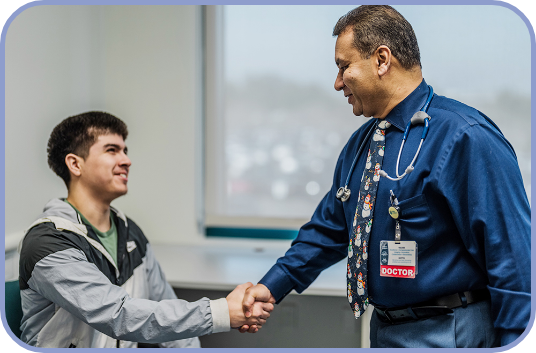 Dr. Vinod Balasa shakes hands with a teenage patient