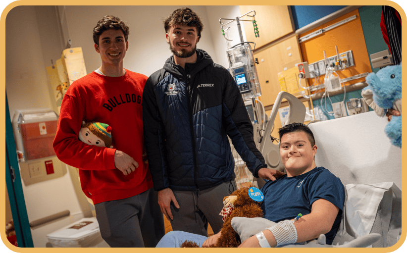 Two Fresno State athletes visit a young patient in the hospital