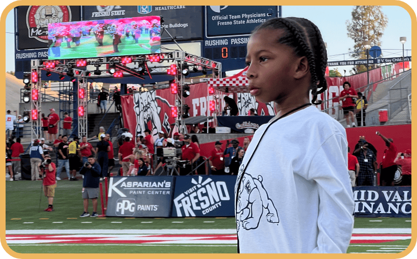 A young boy watches the Fresno State marching band