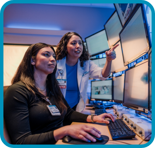A doctor and colleague point at a screen